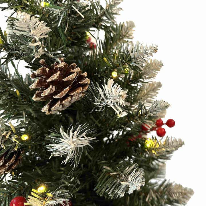 Close-up of a decorated Christmas tree with pine cones, lights, and berries