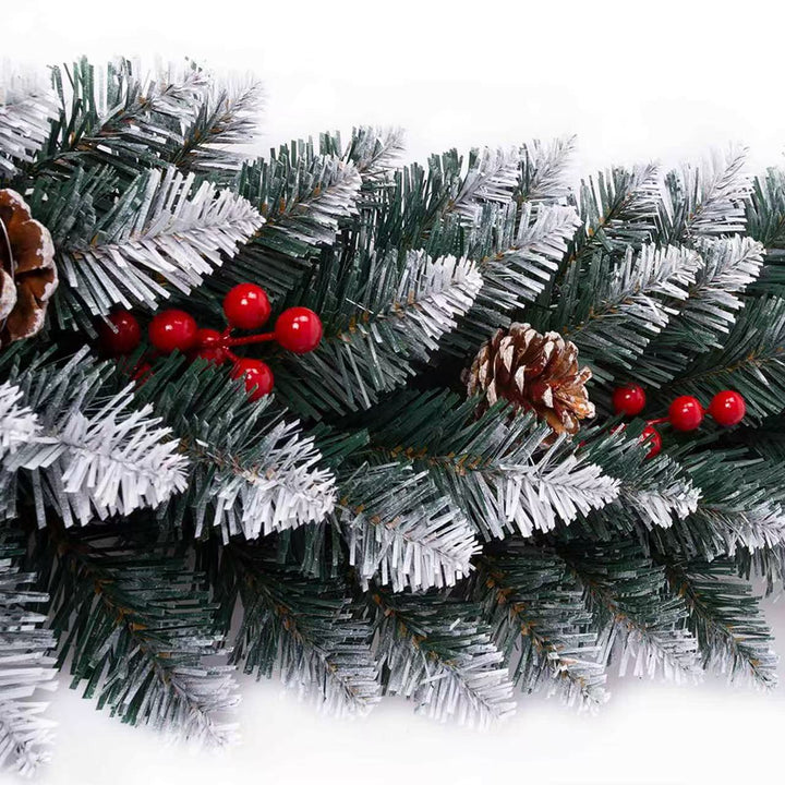 Christmas garland with green pine branches, red berries, and pine cones