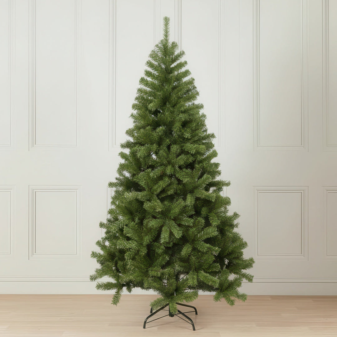 Green artificial Christmas tree against a white paneled wall.