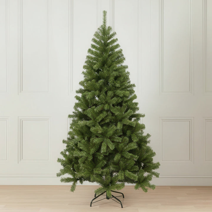 Green artificial Christmas tree against a white paneled wall.
