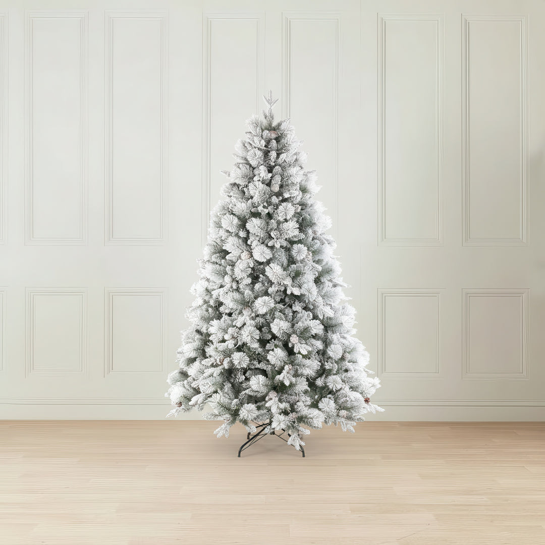 Frosted Christmas tree in a room with white paneled walls and wooden floor.