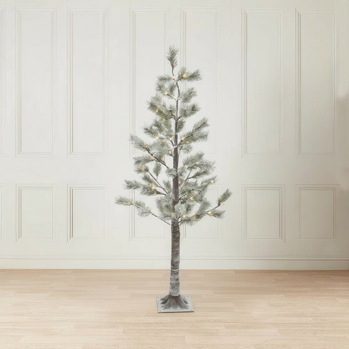 6ft Snowy Pine LED Christmas tree with lights on a wooden floor against a white paneled wall.